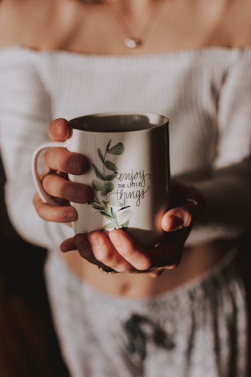Person Holding White and Green Mug