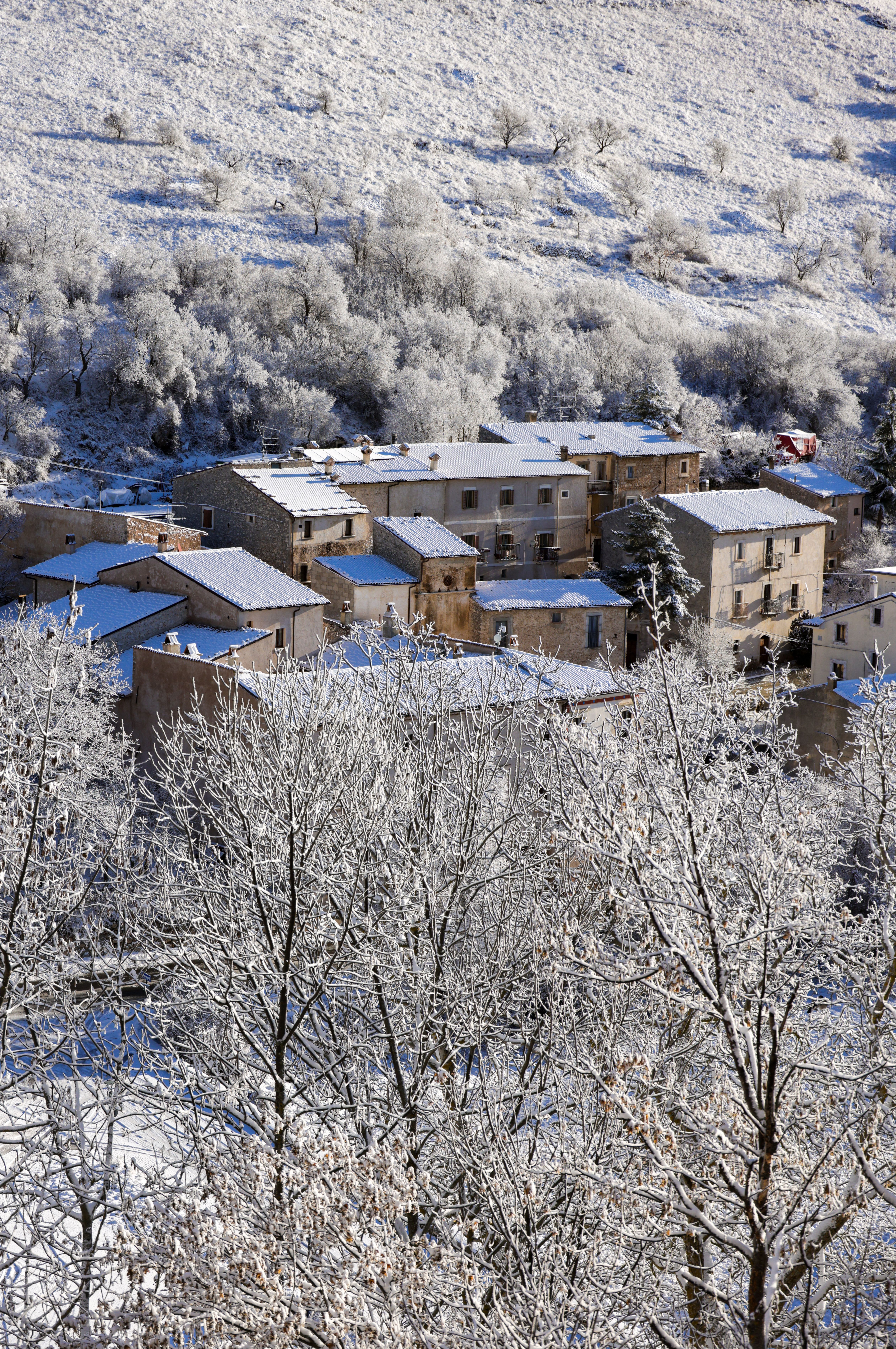Picturesque Italian village blanketed in snow, offering a serene winter wonderland view.