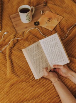 一个人舒服地躺在床上，喝着咖啡，享受轻松的阅读时光