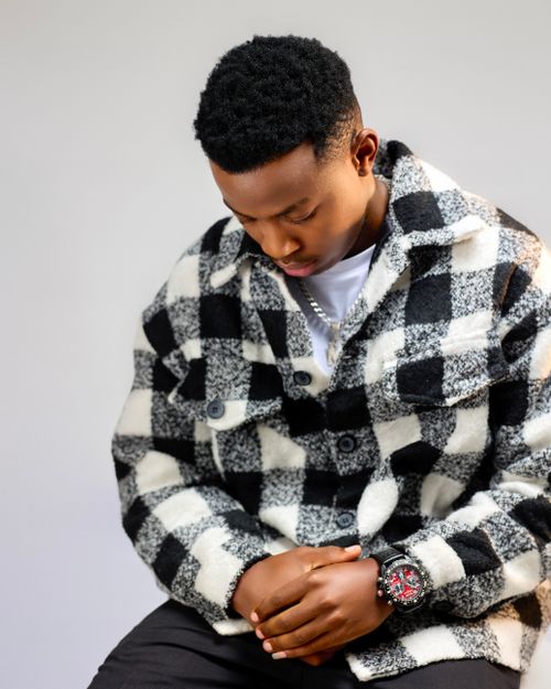Free Trendy young adult wearing a checkered jacket, showcasing modern fashion indoors. Stock Photo