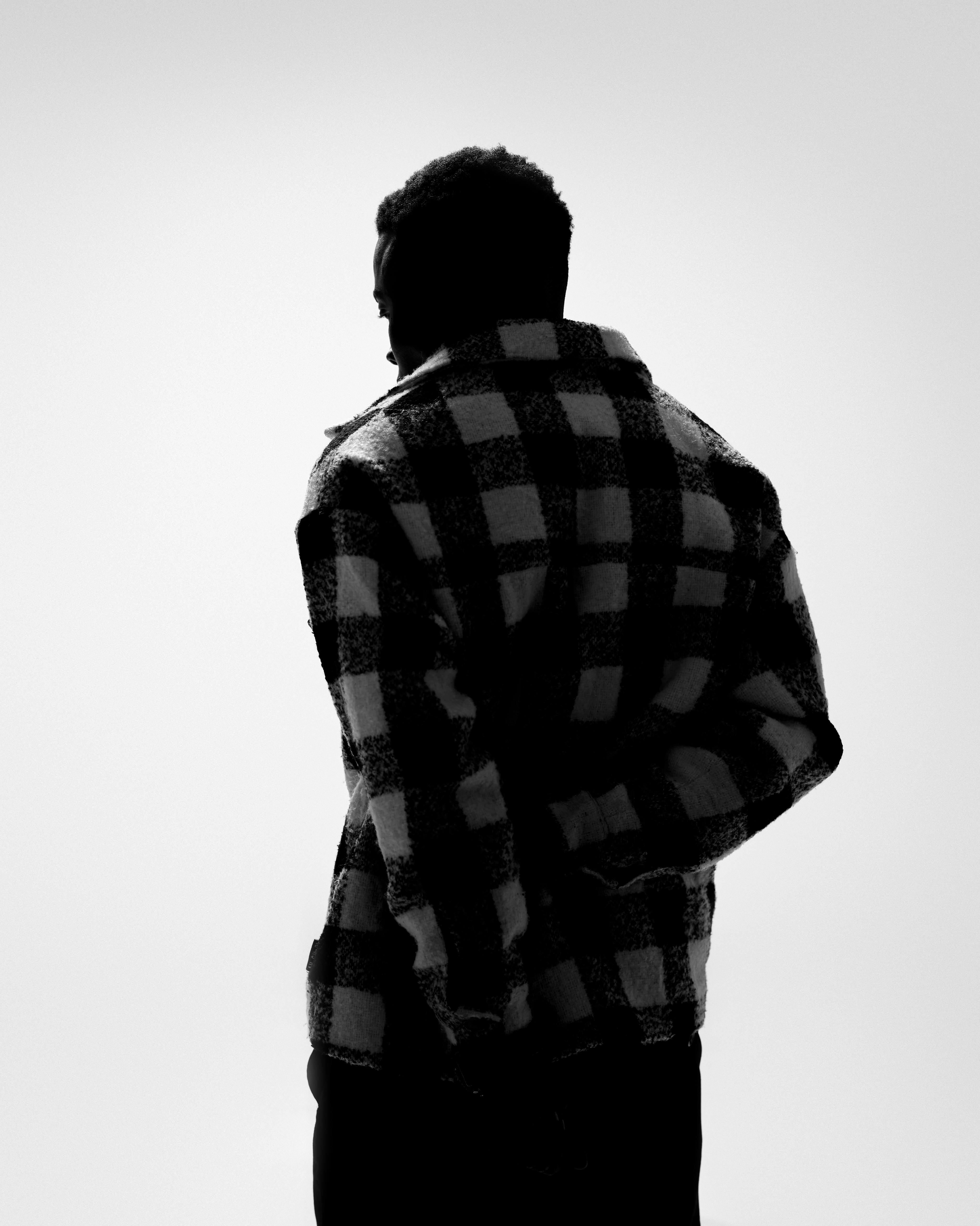 Free Silhouette of a man wearing a plaid coat, captured in a minimalist and artistic style. Stock Photo