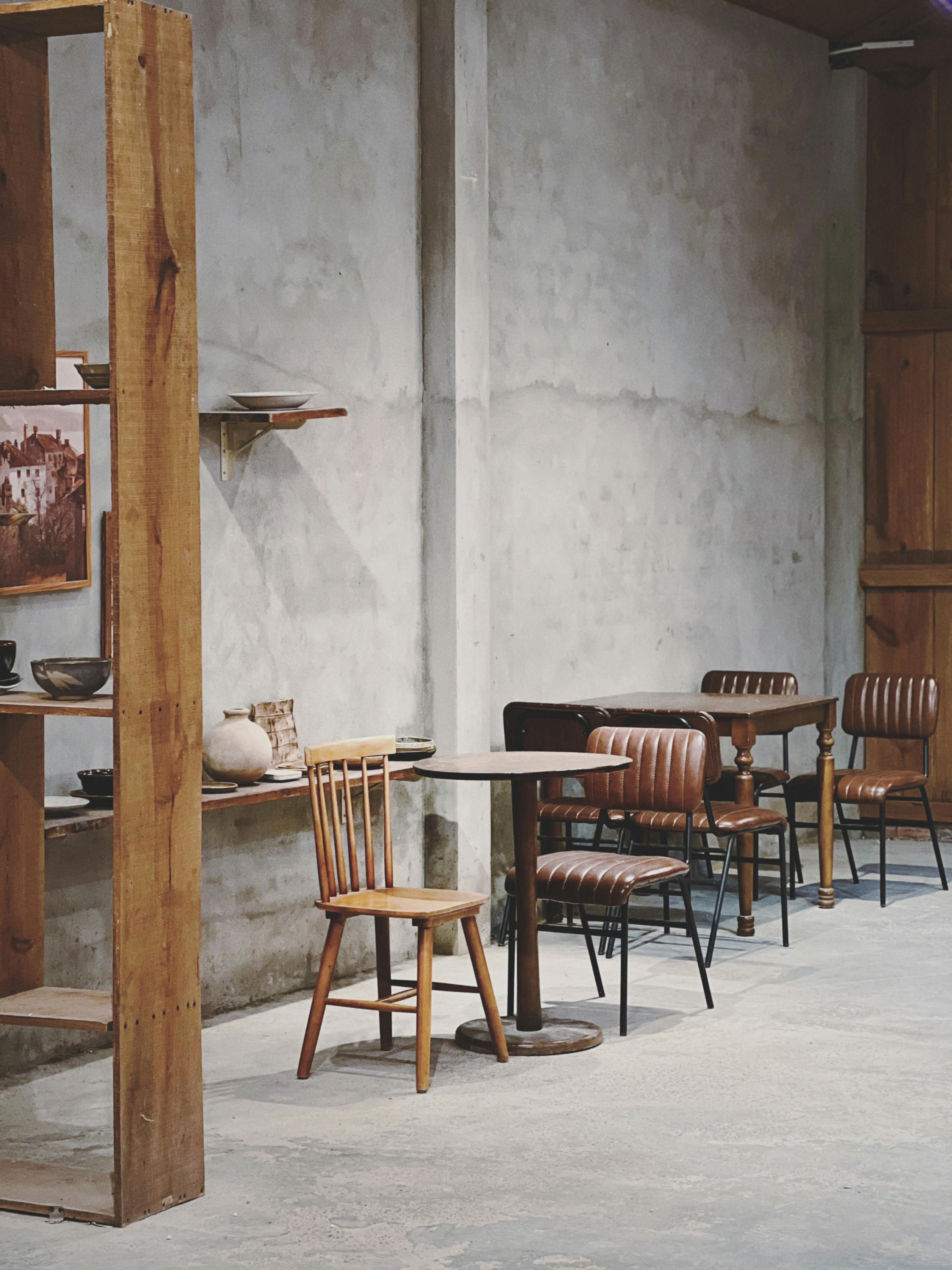 Gratuit Un interior rustic confortabil de cafenea, cu mobilier din lemn și pereți de beton, perfect pentru o atmosferă liniștită. Fotografie de stoc