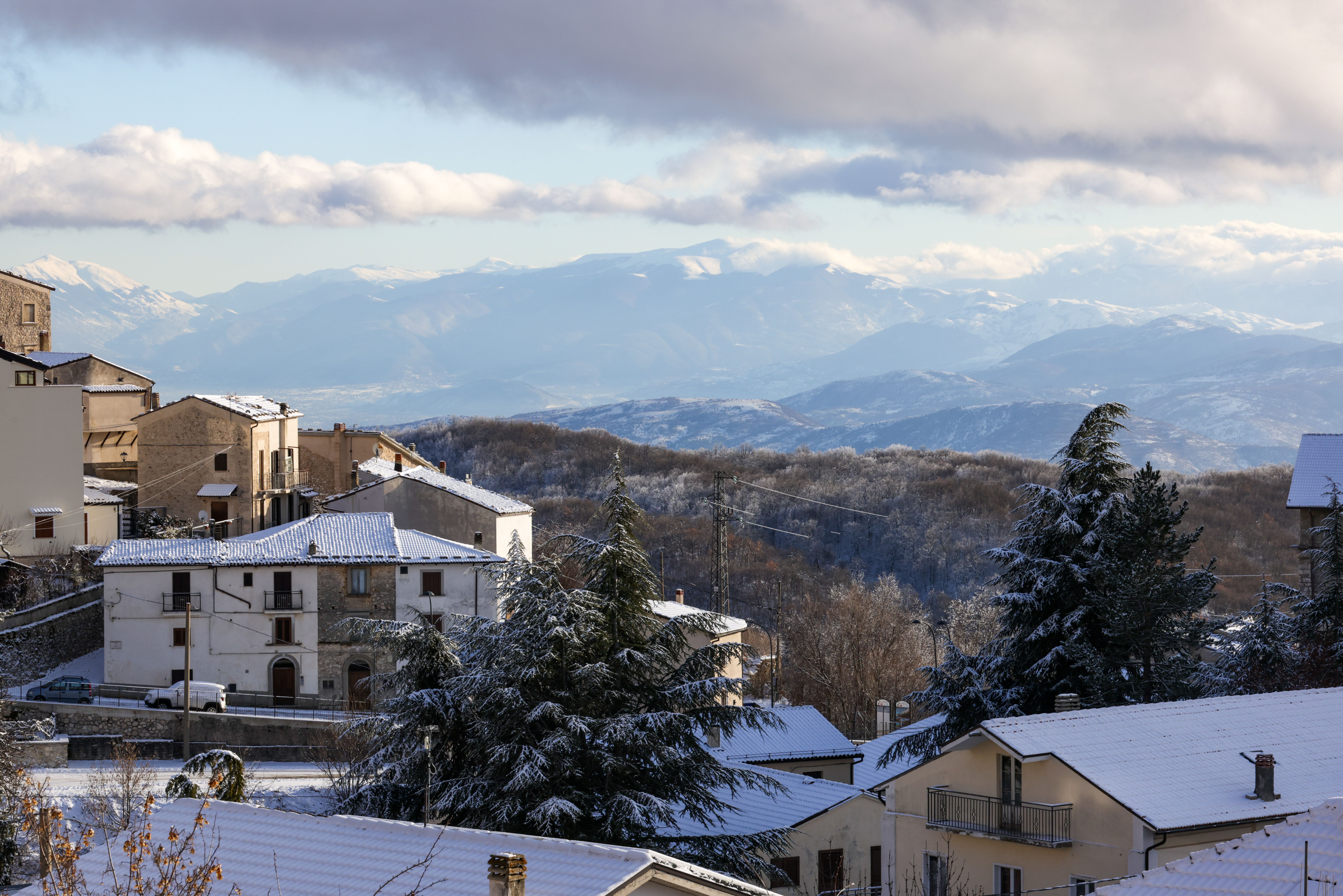 Picturesque snow-covered Italian village with mountain views in winter.