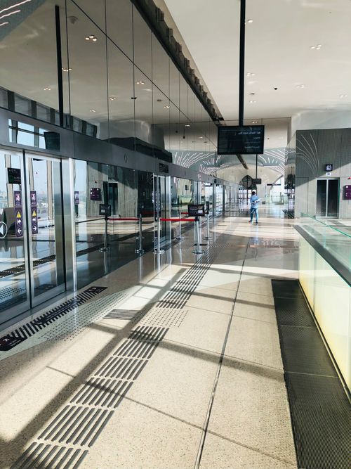 Free Spacious empty airport terminal hallway with modern design and sunlight streaming through. Stock Photo