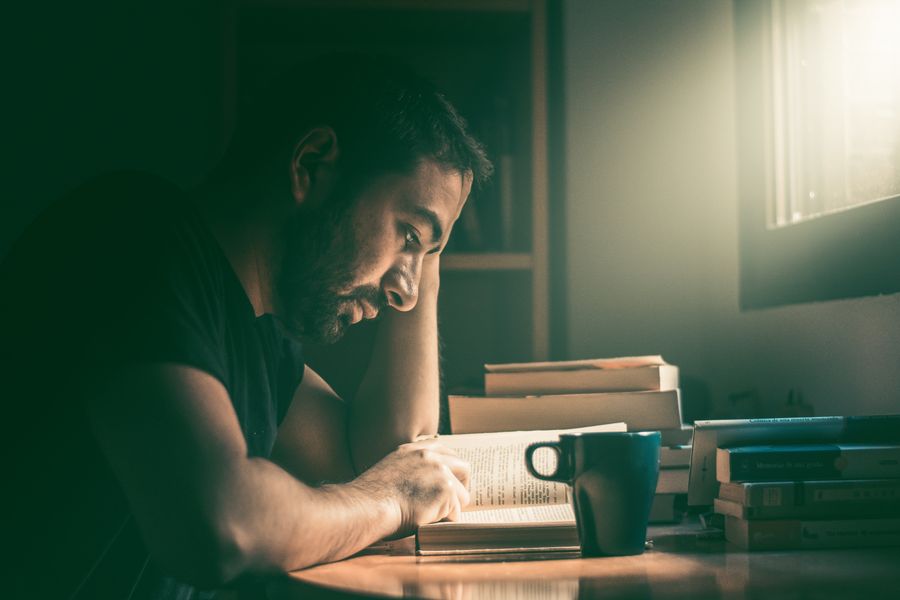 Man reading by a window, photo by Ariel Castillo on Pexels