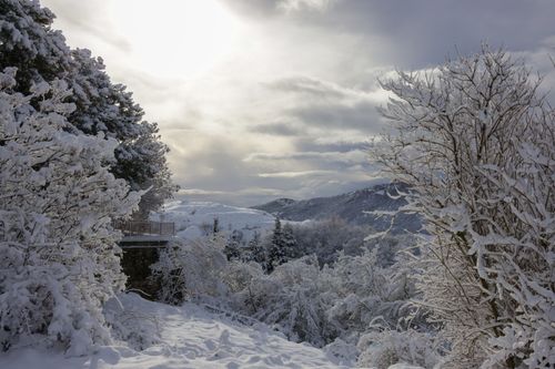 Free A serene snowy landscape with mountains under a cloudy winter sky. Stock Photo