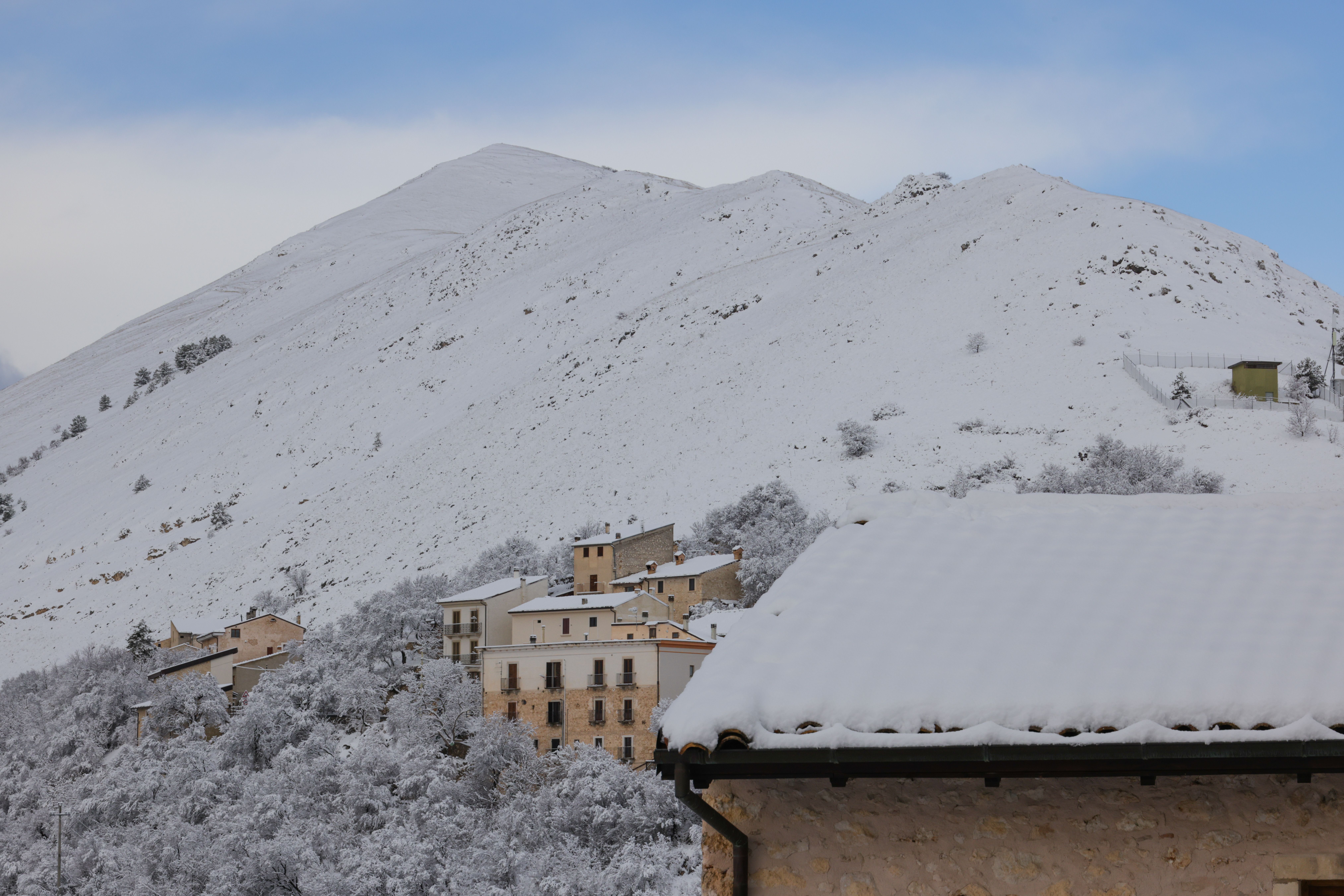 Gratis Incantevole villaggio innevato, incastonato tra le montagne italiane, che offre tranquillità invernale e bellezze naturali. Foto a disposizione