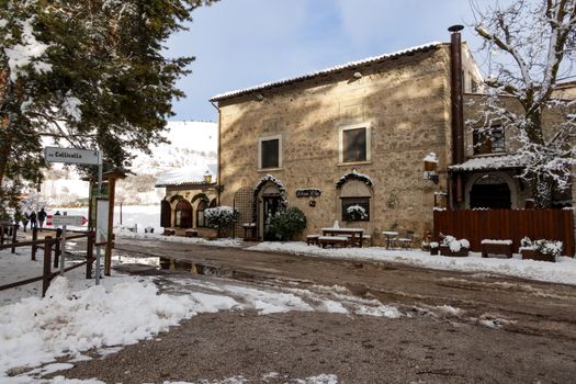 Picturesque Italian village covered in snow, showcasing rustic architecture and a serene winter scene.