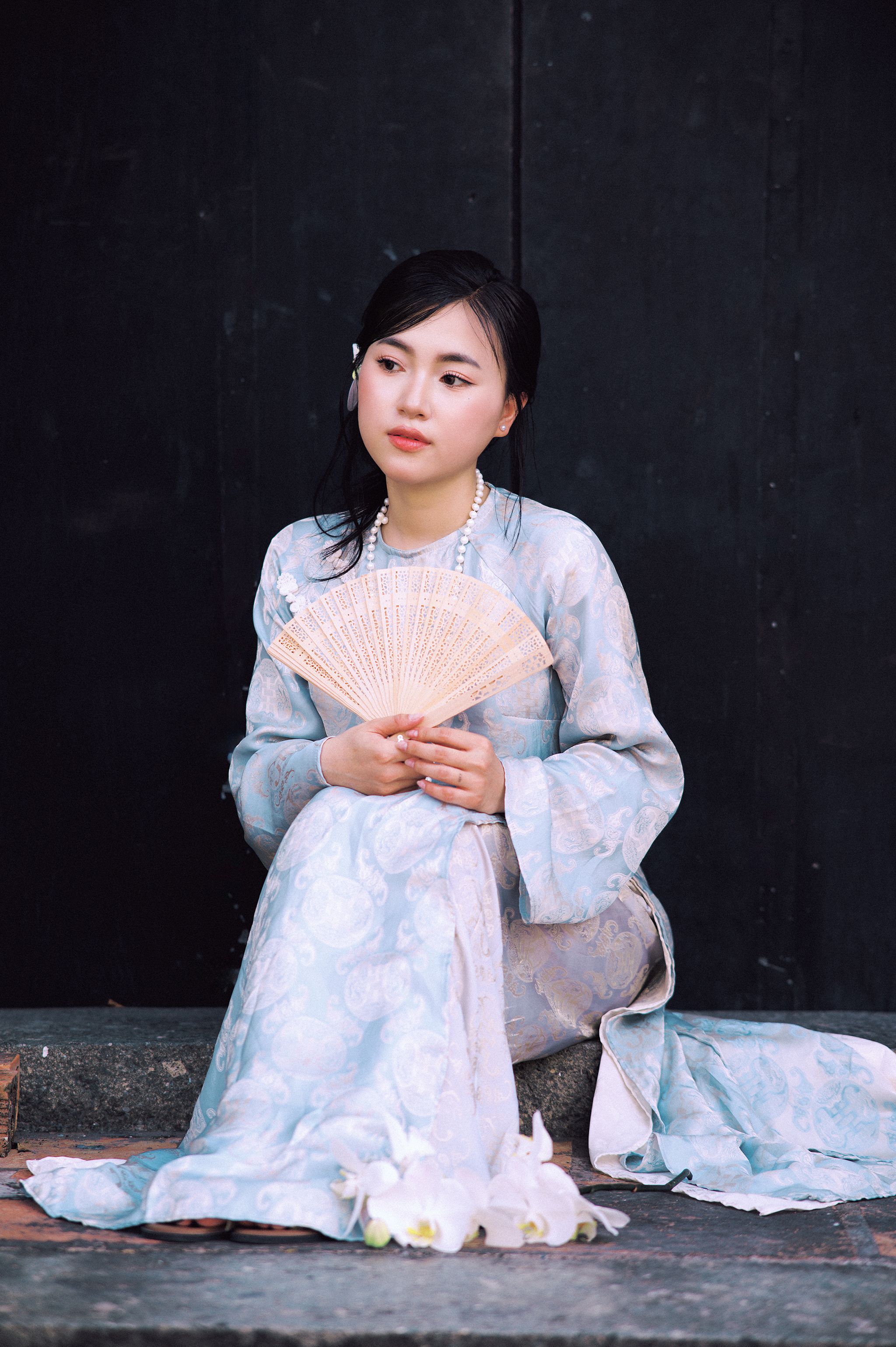Portrait of a Vietnamese woman in Áo Dài holding a fan in Sa Đéc, Vietnam.