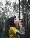 一位年轻女子在森林里披着盖巾拍摄的侧视图