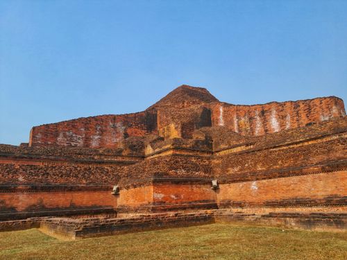 Free A historic brick mound stands prominently under a clear blue sky in an open field. Stock Photo