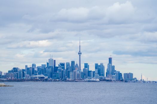 Dramatic Toronto skyline featuring the iconic CN Tower under a cloudy sky.