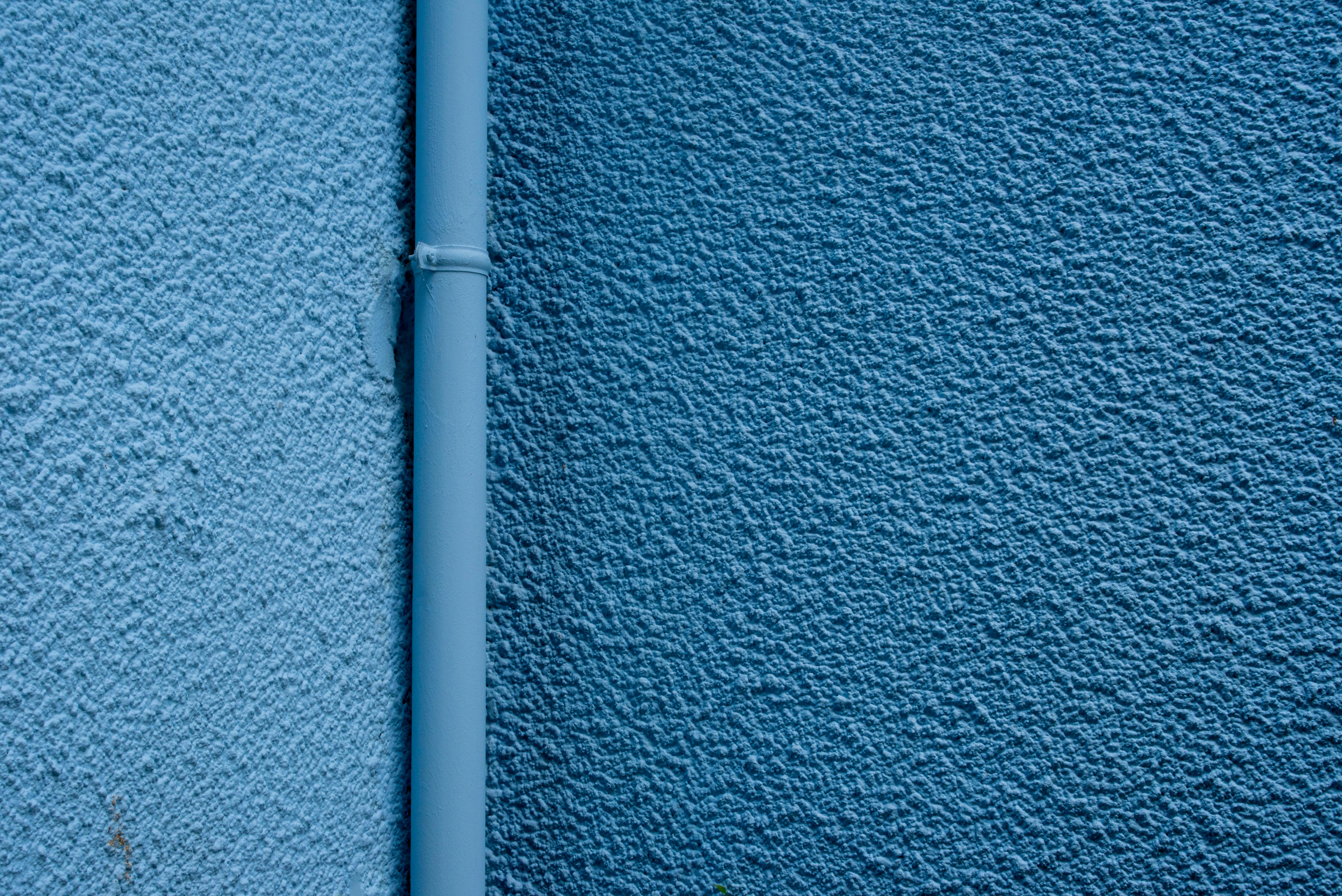 bezplatná Detail modré texturované zdi s úzkou svislou odtokovou trubkou. Základová fotografie