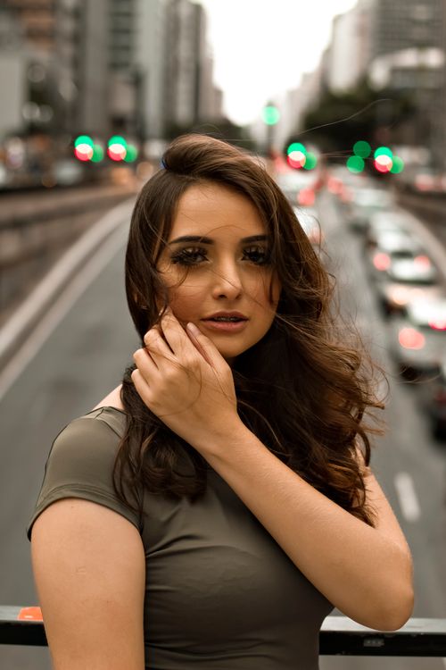 Free Urban portrait of a woman with flowing hair, standing in São Paulo's bustling street. Stock Photo