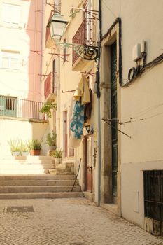 Discover this serene sunlit alley in Lisbon, showcasing the city's charming old-world architecture and vibrant colors.