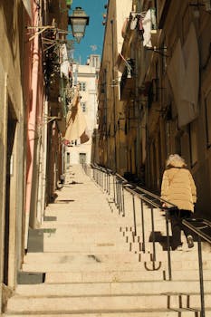 Explore a picturesque street in Lisbon with steep steps and traditional architecture. Ideal for travel enthusiasts.