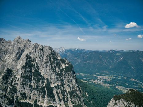 A breathtaking aerial view of a rugged mountain range under a clear blue sky.