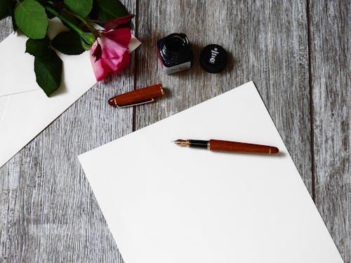 Pluma Estilográfica Marrón Y Negra Sobre Papel Blanco