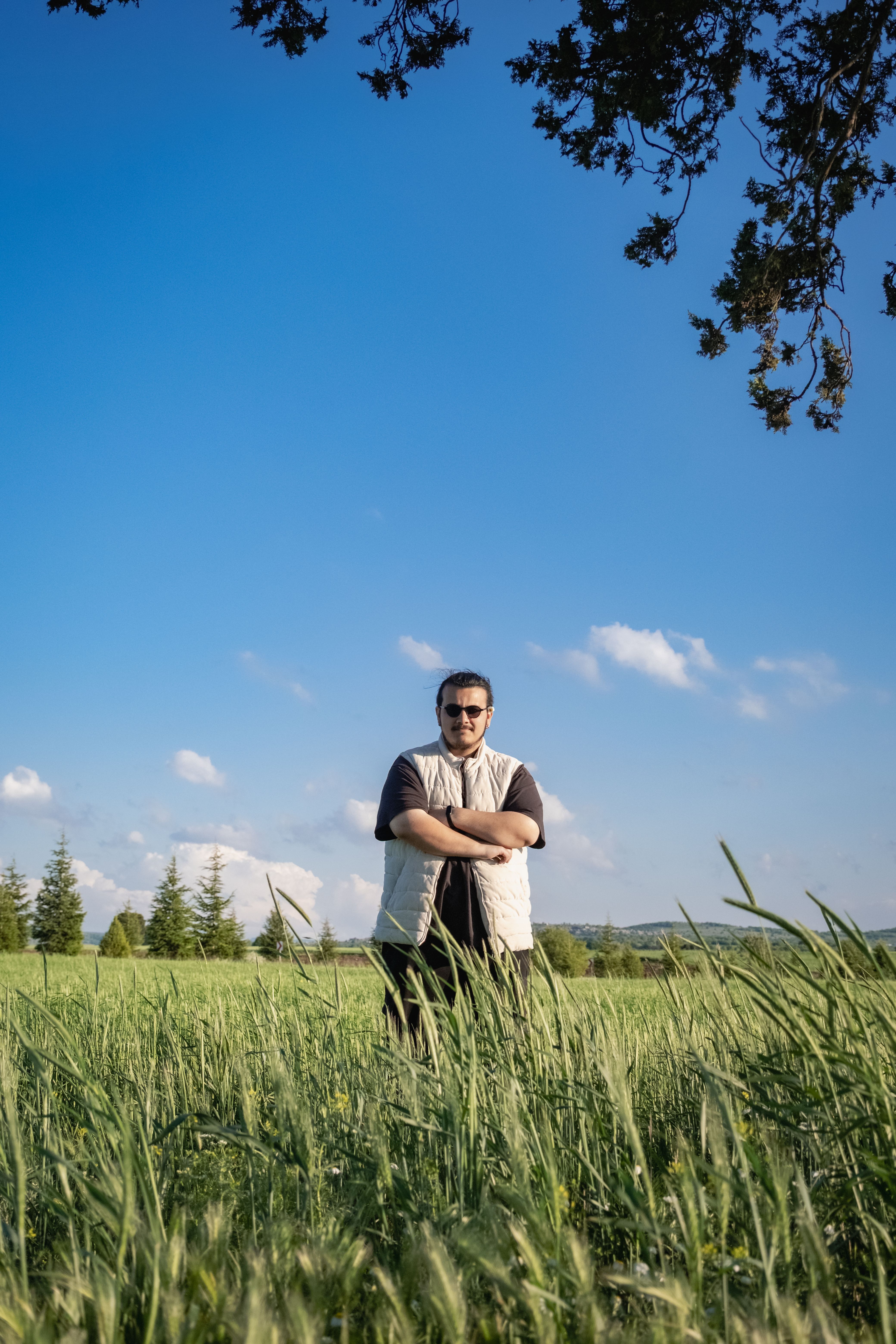 Man Standing in Lush Green Field Under Blue Sky · Free Stock Photo