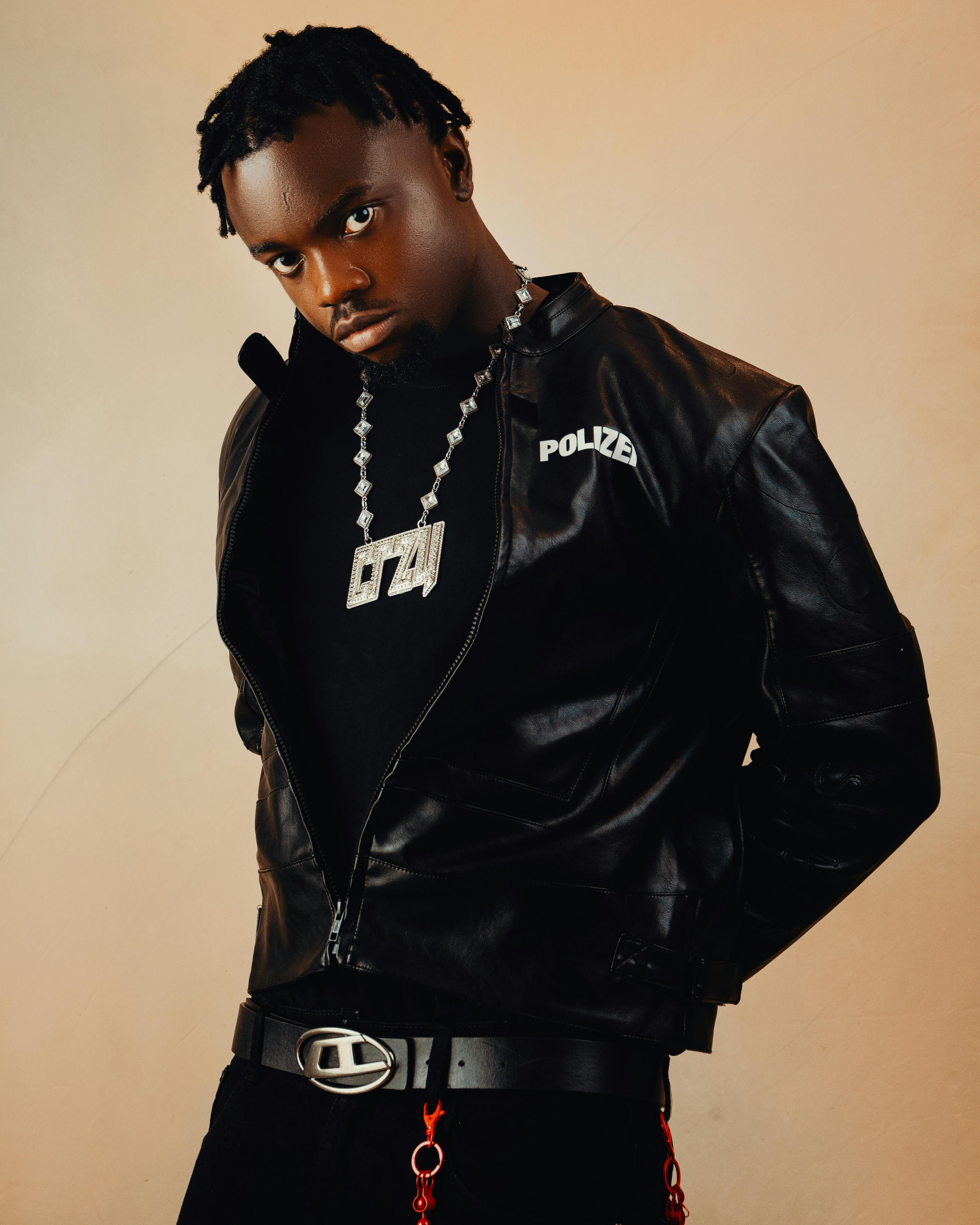 Stylish portrait of a man wearing a black leather jacket with bold jewelry.