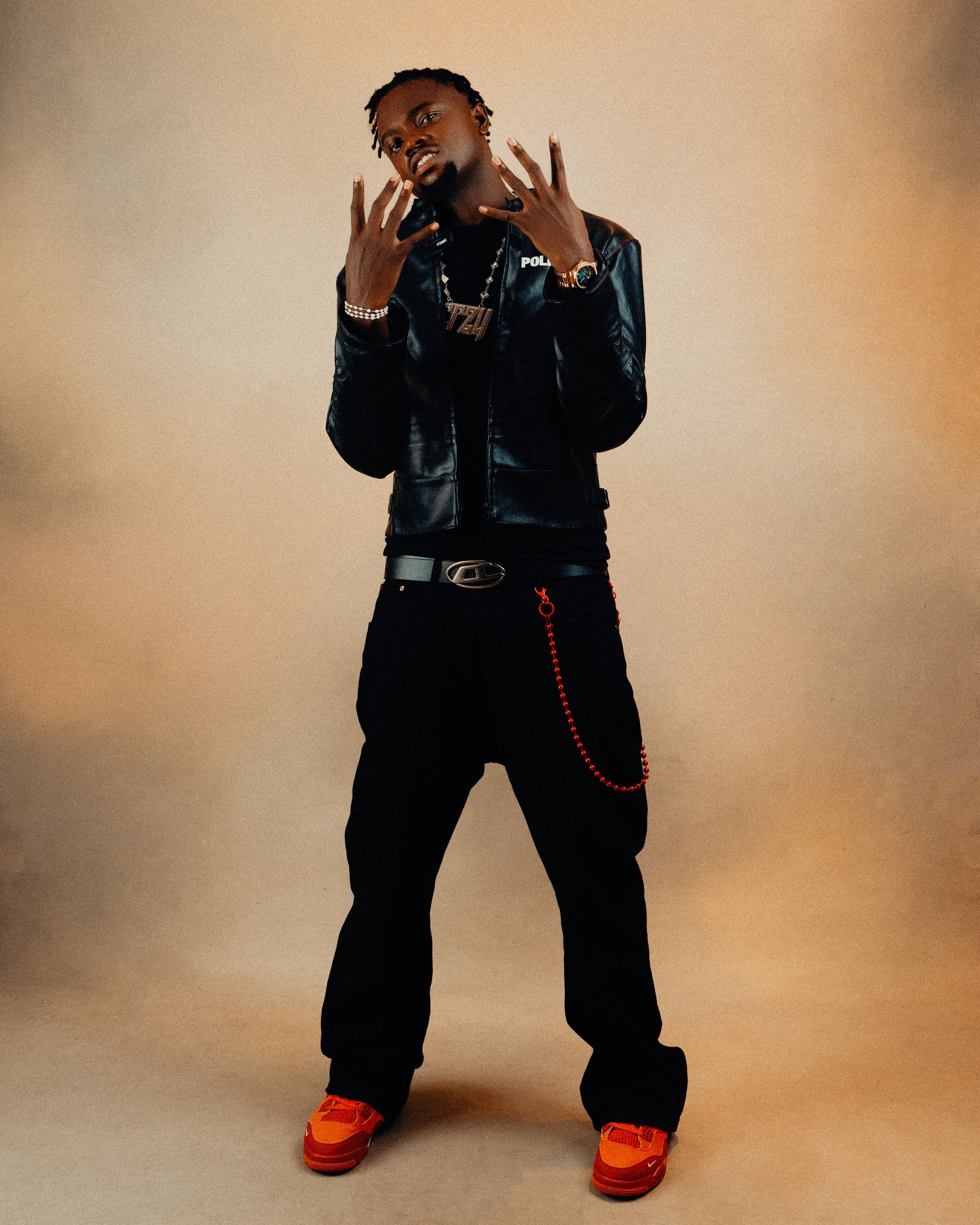 Confident young man in a leather jacket with bold expression and stylish pose.