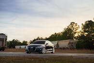 Black Car Parked by Train Tracks at Sunset