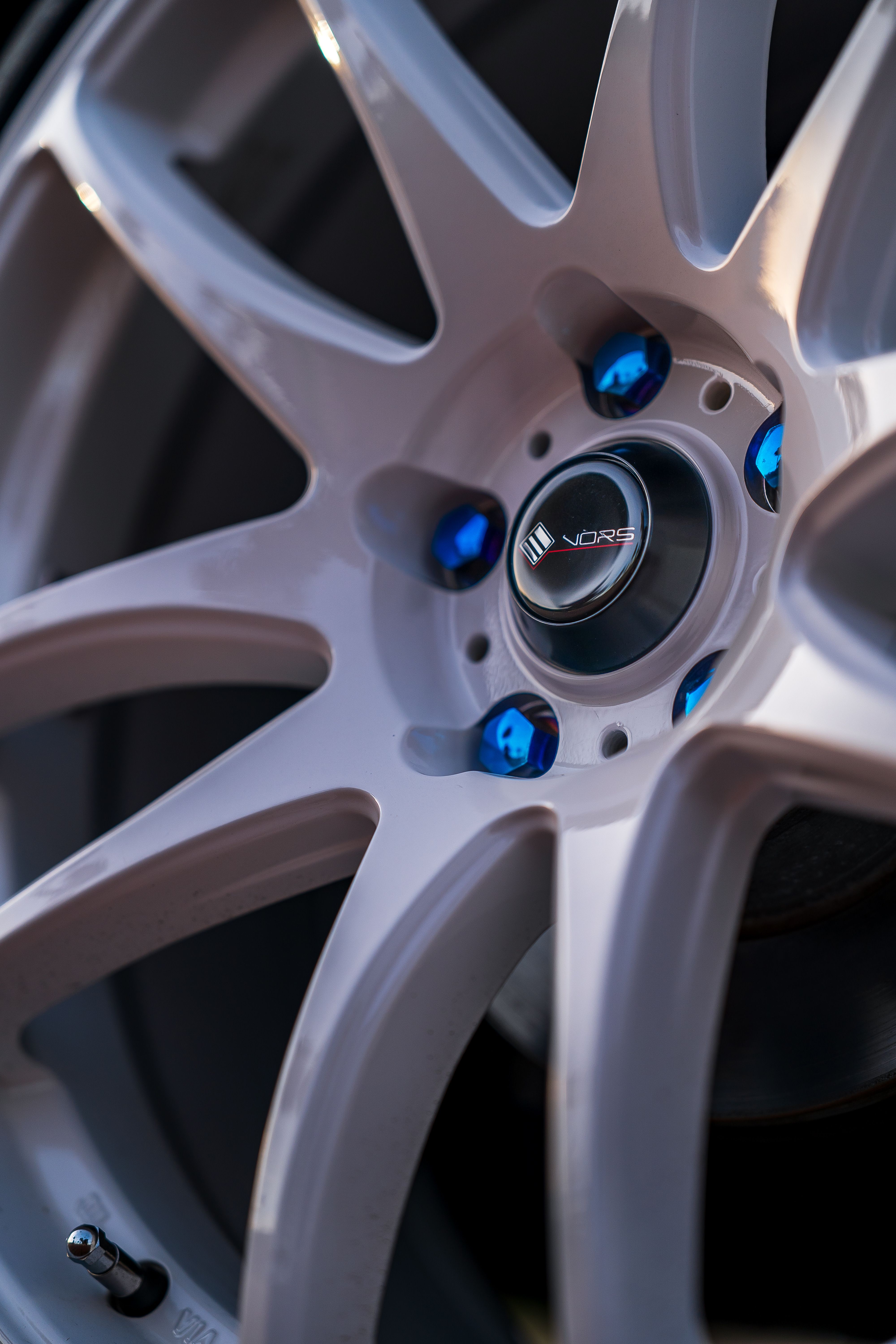 Close-up of alloy wheel with blue lug nuts arranged in a star pattern configuration