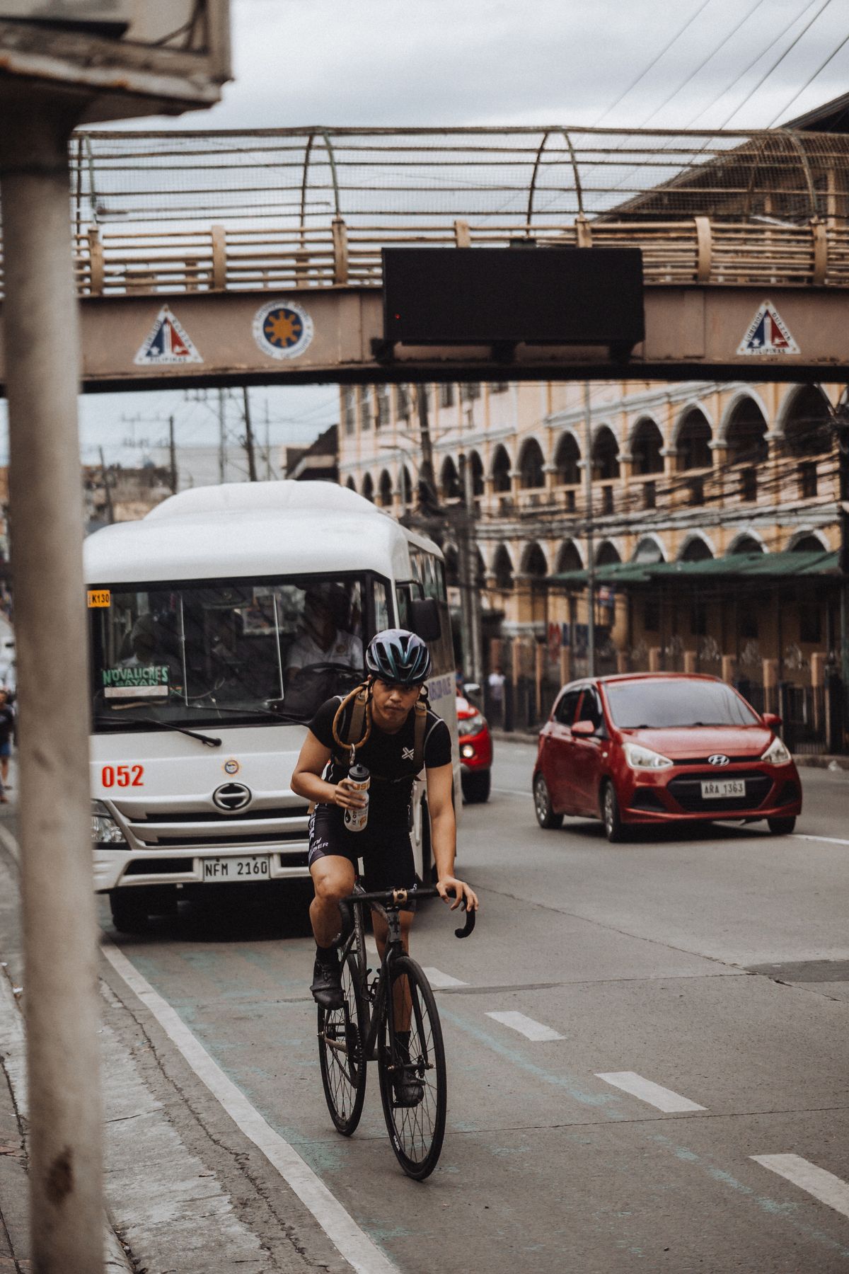Urban cyclist wearing protective gear while riding among city traffic