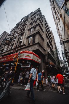 A bustling urban street scene with pedestrians and shops in an Asian city, showcasing lively everyday life.