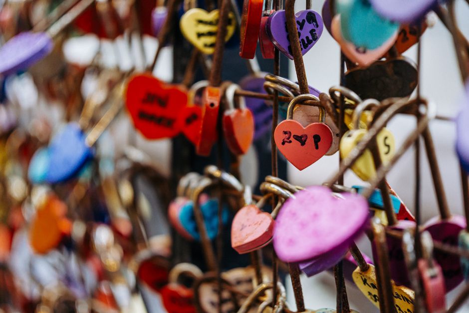 Vibrant heart-shaped padlocks attached to a bridge fence symbolizing love and commitment.