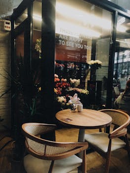 Charming café table beside a floral display in a cozy indoor setting, ideal for relaxation.