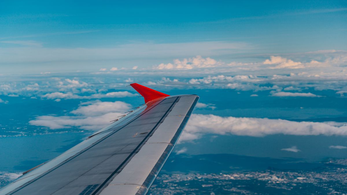 Stunning aerial view from airplane window showcasing wing and expansive ocean below.