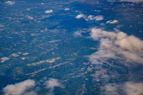 Free Stunning aerial shot showcasing green landscapes and clouds from above, ideal for travel and nature themes. Stock Photo