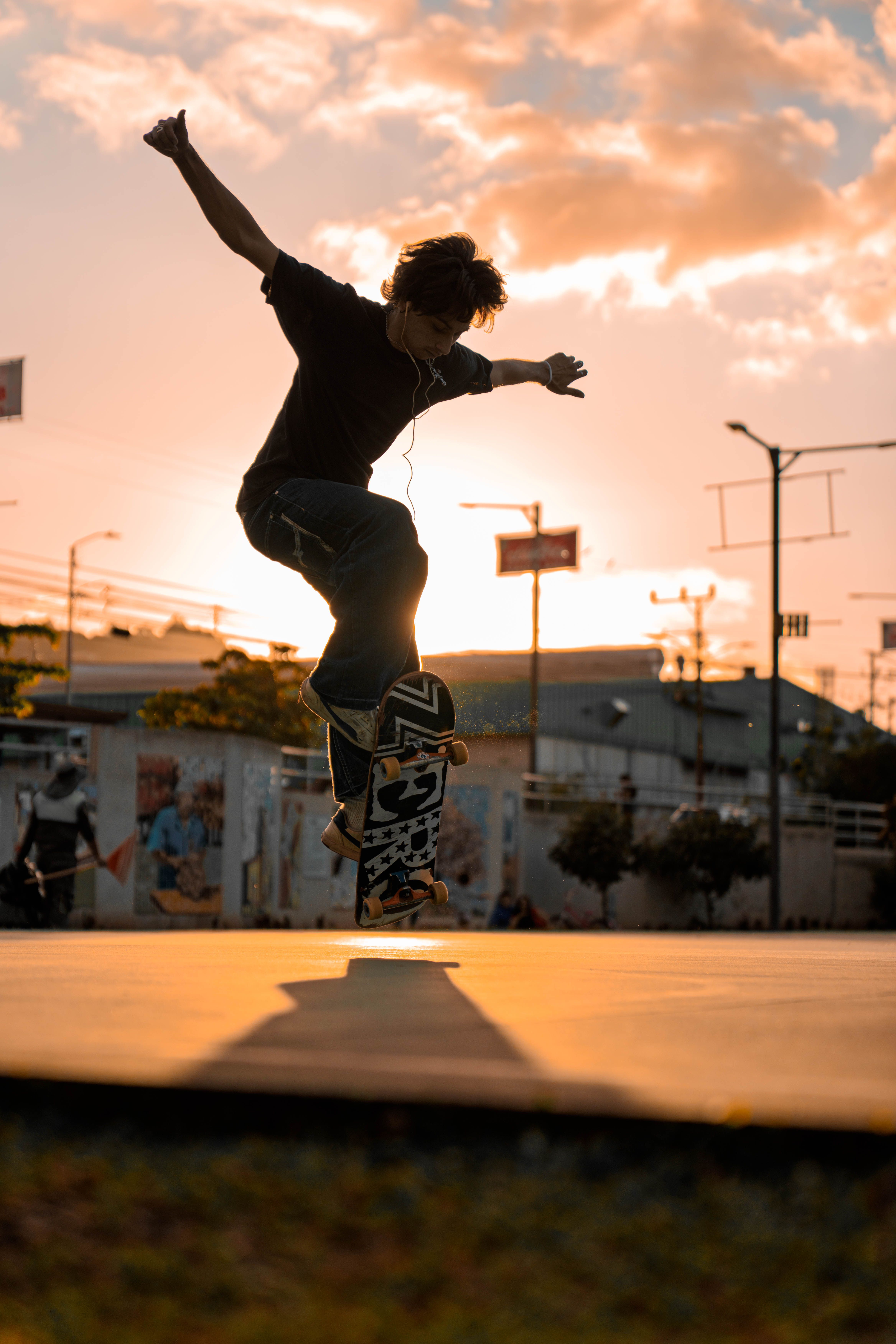 Skateboarder mid-trick against a golden sunset, photo by Juan Jesus Madrigal Herrera on Pexels