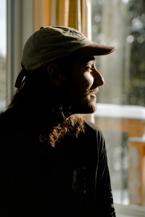 Man Wearing Cap Near Window