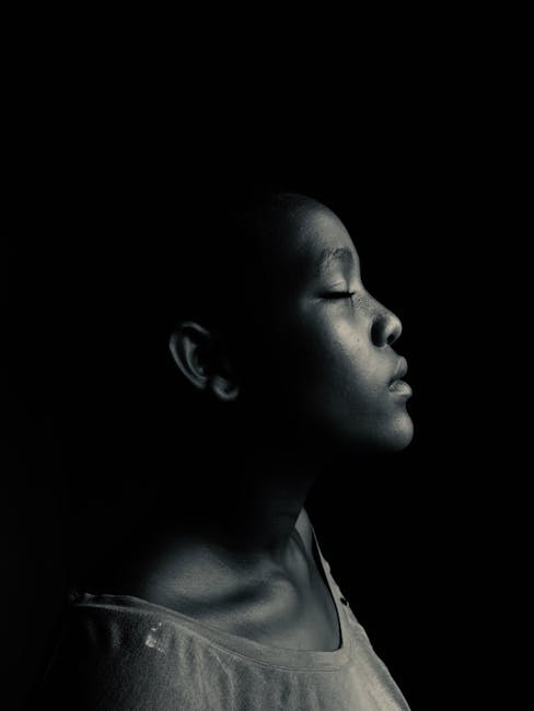 Artistic black and white side-profile portrait of a serene woman with closed eyes.