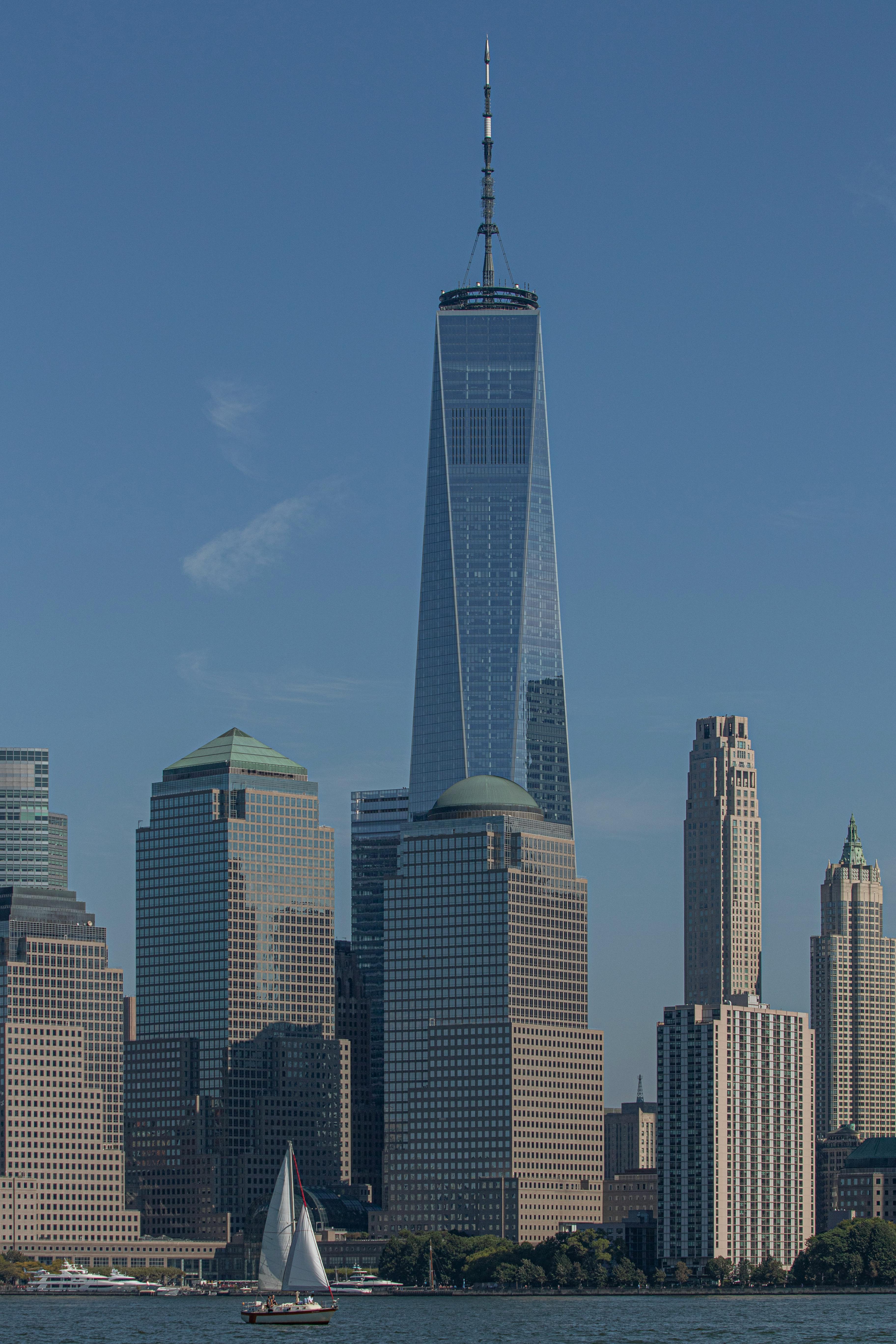 Zadarmo One World Trade Center sa týči vysoko medzi panorámou New Yorku pod jasnou modrou oblohou. Fotka z fotobanky