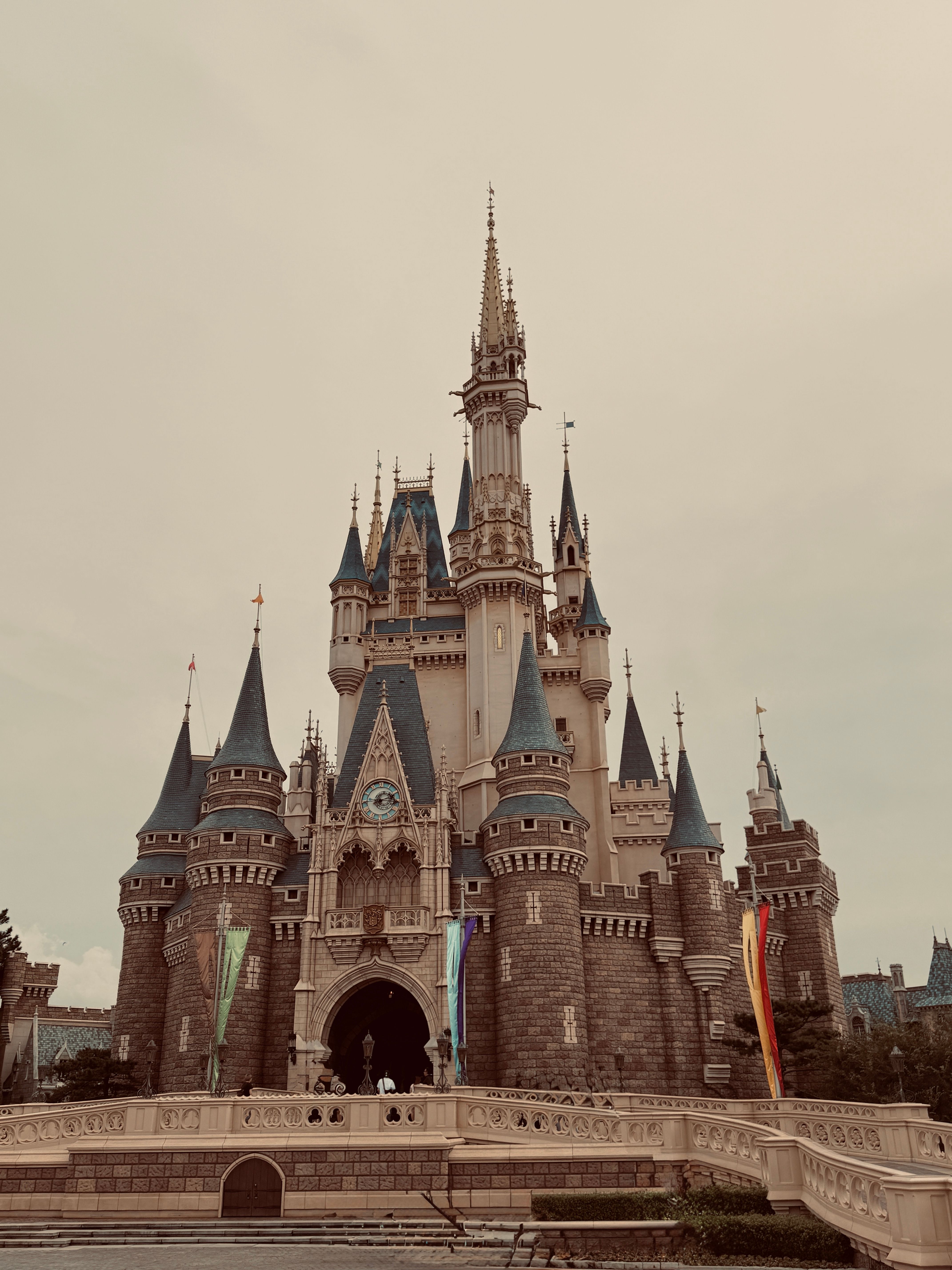 A vintage-style photo of the iconic castle at Tokyo Disneyland on a clear day.