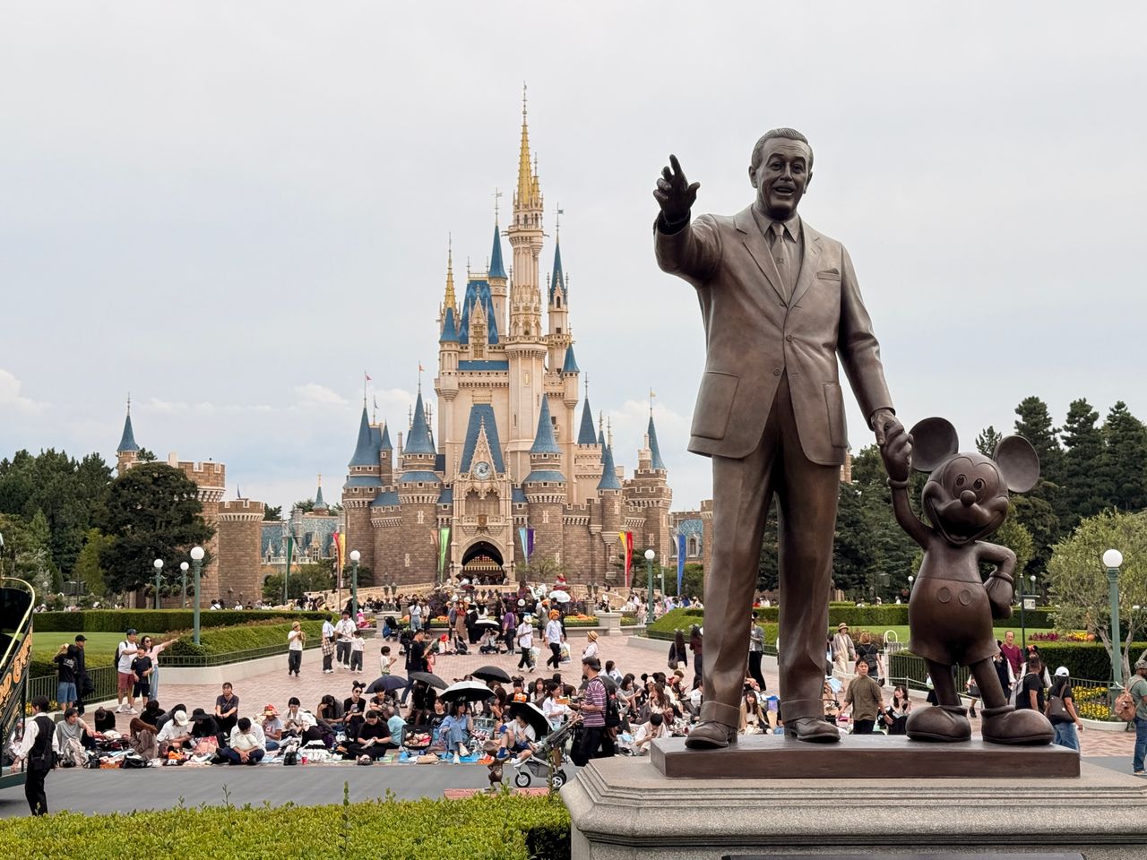 statue of walt disney and mickey mouse in front of cinderella castle t