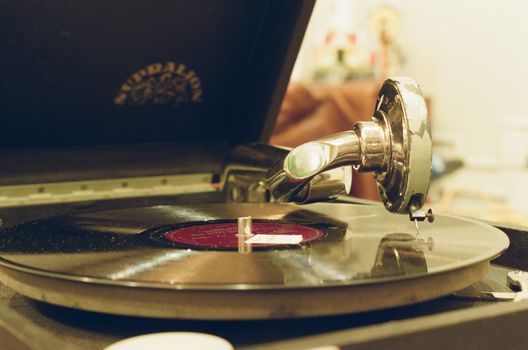 Close-up of a vintage gramophone playing a classic vinyl record indoors.