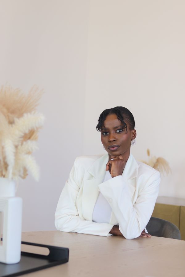 Woman in a tailored cream suit with a silk camisole