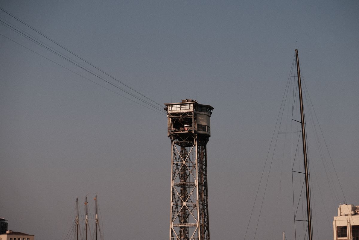 Turnul telefericului portuar la apus, cu catargul unui velier