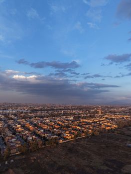 Aerial cityscape view during twilight with wide sky, capturing the blend of urban and natural beauty.
