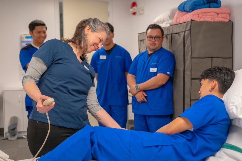 Healthcare professionals in a training session using medical equipment indoors.
