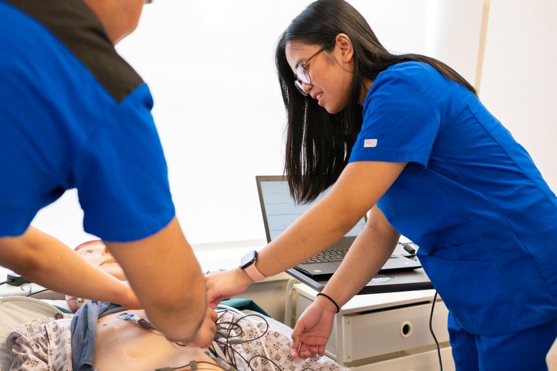Nursing students training with a medical mannequin in a simulation lab