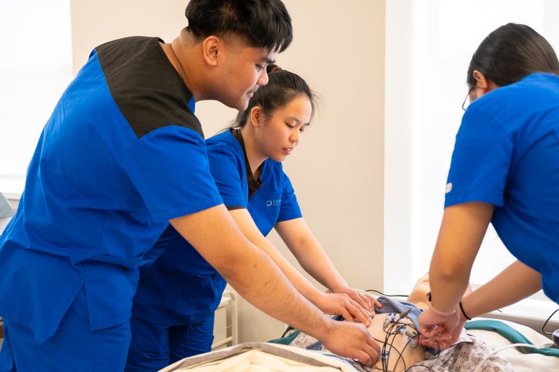 Group of nursing students practicing a clinical procedure in a training room