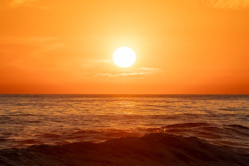 Free Stunning sunset over the Pacific Ocean with golden hues reflecting on the water at El Salvador beach. Stock Photo