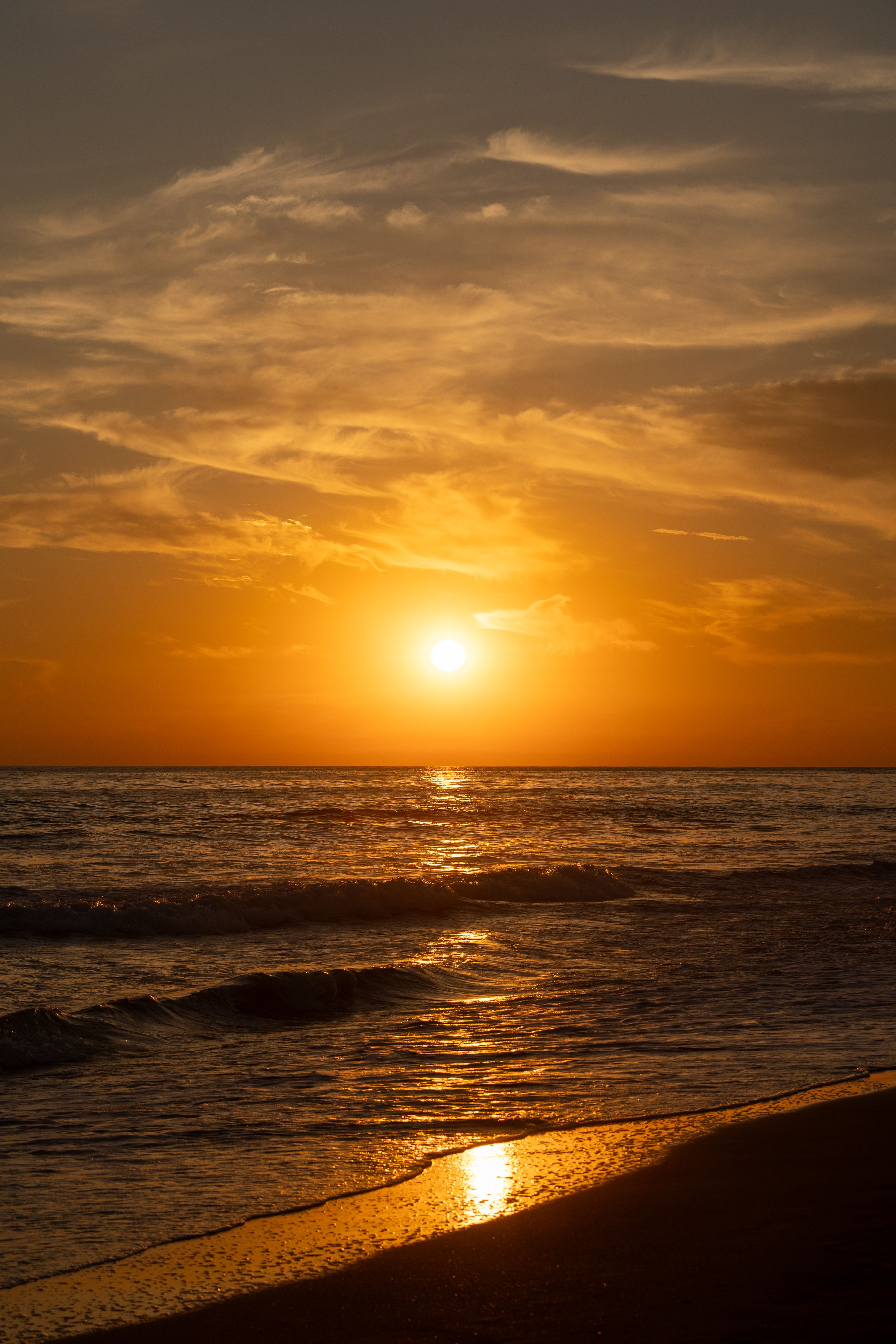 Golden sunset over a tranquil El Salvador beach, capturing serene waves and warm hues.