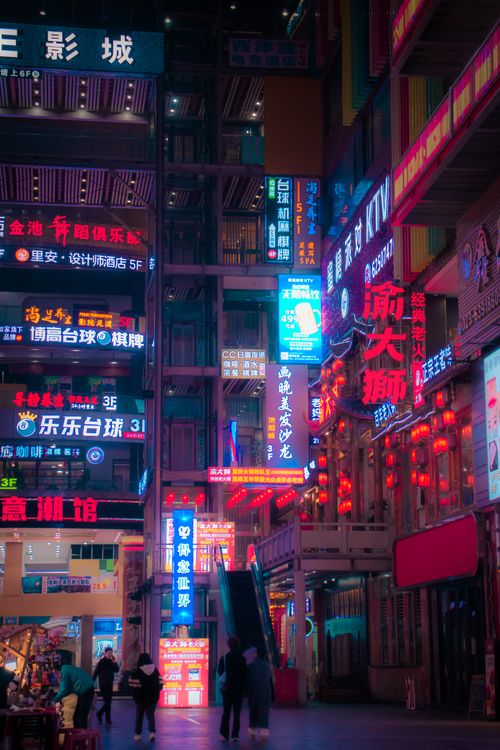 Free A bustling urban street scene illuminated by colorful neon lights in an Asian city at night. Stock Photo