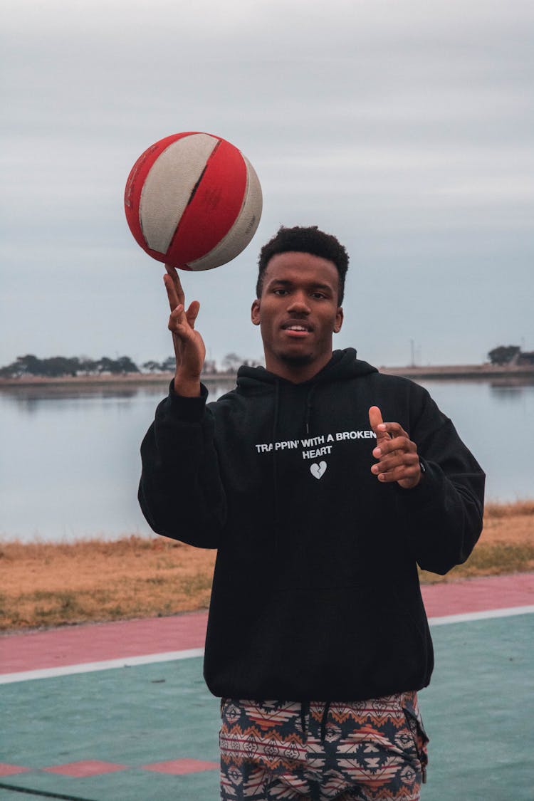 Man In Black Hoodie Spinning A Ball